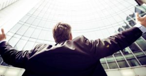 man with outstretched arms by office building