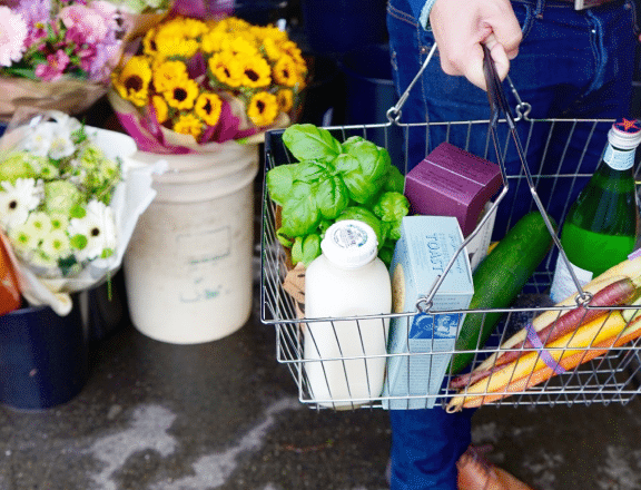 a photo of a hand-carried grocery basket containing food items