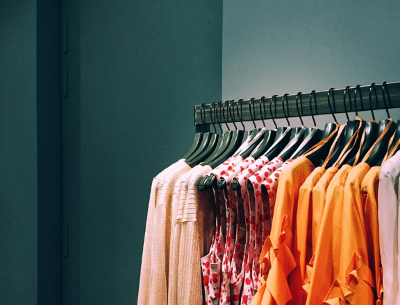 pink and orange clothes hanging on a rack